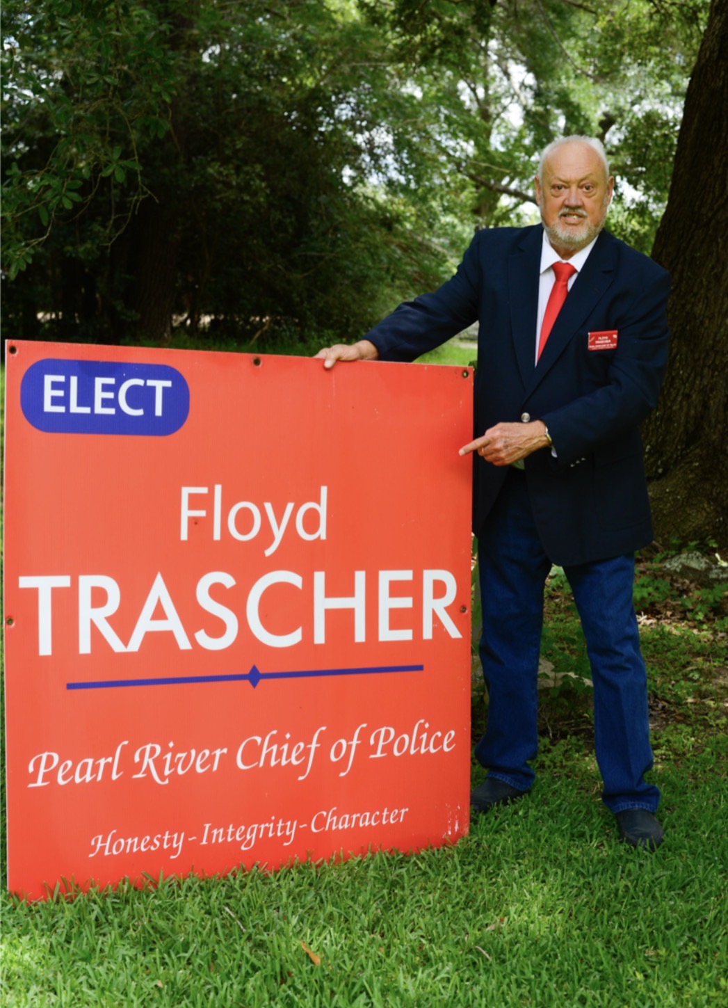 Floyd Trascher standing beside a campaign sign